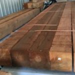 Stacked wooden beams in a warehouse.