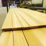 Smooth wooden planks stacked in a workshop.