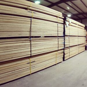 Stacks of wooden planks neatly arranged inside a warehouse.