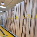 Stacks of wooden planks lined up in a storage aisle.